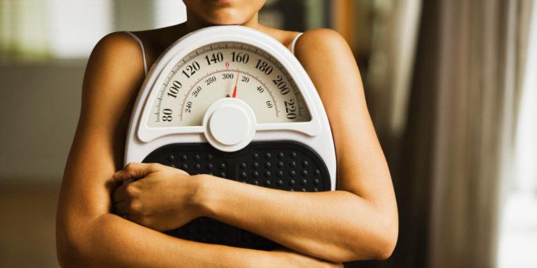 fogyokura_beautymagazin_egeszseg_201801-e1515149246783 Hispanic woman holding bathroom scale