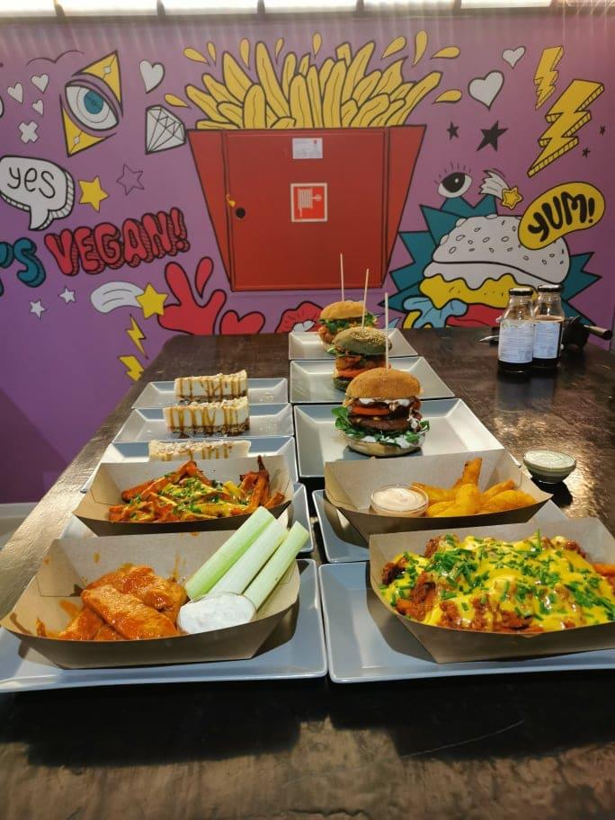színes fal előtt street food ételek a pulton